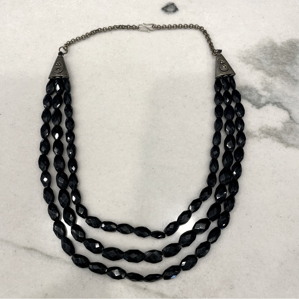 Black faceted beaded three strand necklace.  Semi-precious stones and brass.